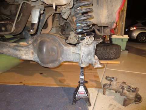 1996 Ford Bronco - Close-up of a vehicle's rear axle assembly and suspension components being worked on.