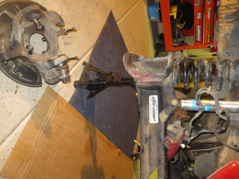 1996 Ford Bronco - Various suspension components, including a spindle, coil springs, and jack stands, are laid out on the floor.