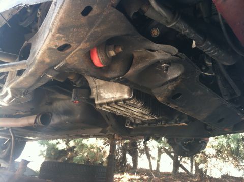 1993 Ford Taurus - The undercarriage of a vehicle is shown, with focus on the suspension components and the engine's oil pan.