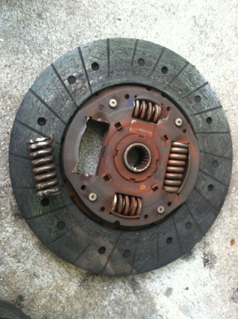1993 Ford Taurus - A worn clutch disc with a broken spring is shown, indicating a need for replacement.