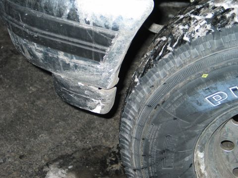 1995 Ford Bronco - Close-up of a 1995 Ford Bronco's tire and fender flare, covered in snow.