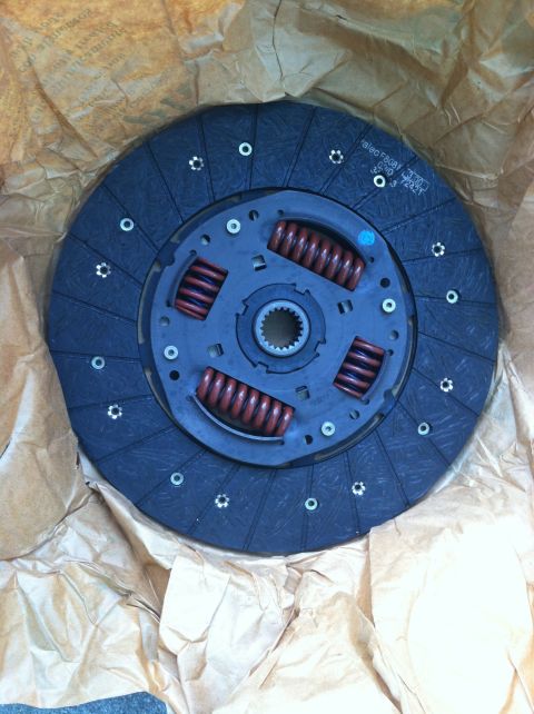 1993 Ford Taurus - A new clutch disc, part of a vehicle's drivetrain, is shown in its packaging.