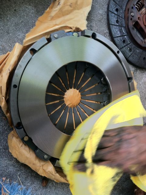 1993 Ford Taurus - A clutch disc and pressure plate are shown, with one part being cleaned.