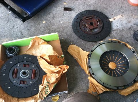 1993 Ford Taurus - New clutch parts are laid out on the ground, ready for installation.