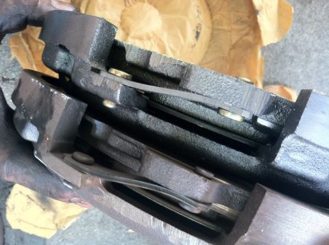 1993 Ford Taurus - Two brake caliper parts are shown in a close-up view, with metal shims visible between them.