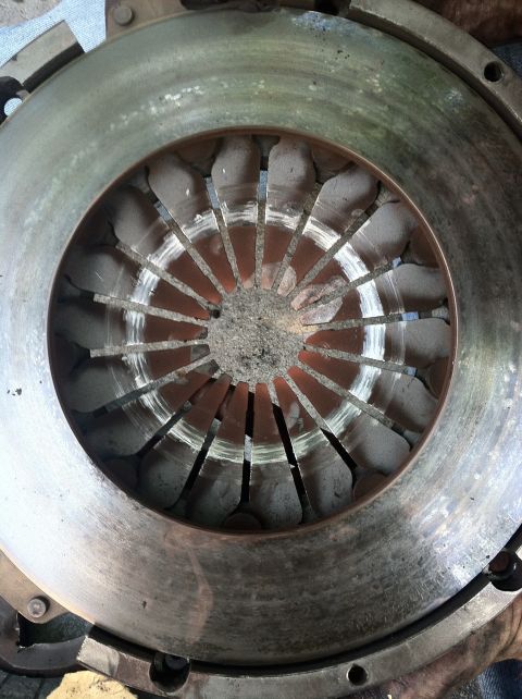 1993 Ford Taurus - Close-up of a worn clutch pressure plate, showing damage to the friction material and bent spring fingers.