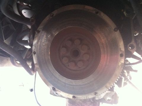 1993 Ford Taurus - A close-up view of a vehicle's flywheel, showing the central bolts and the outer gear teeth.