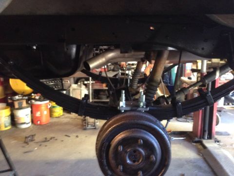 1979 Ford Bronco - Close-up view of a vehicle's rear suspension system, including leaf springs, shock absorber, and brake drum.