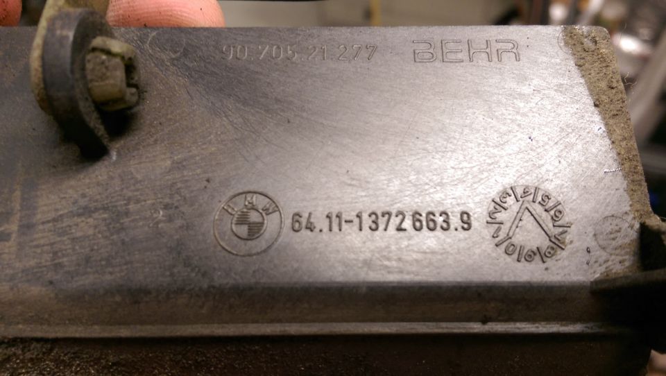 Metal part with BMW logo, BEHR logo, and part numbers.