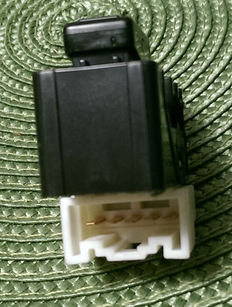 Black electrical component with white connector and gold pins