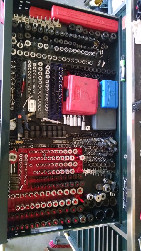 1994 Ford Bronco - A top-down view of a mechanic's toolbox drawer filled with various sockets, wrenches, and other tools. The tools are neatly organized in ro…