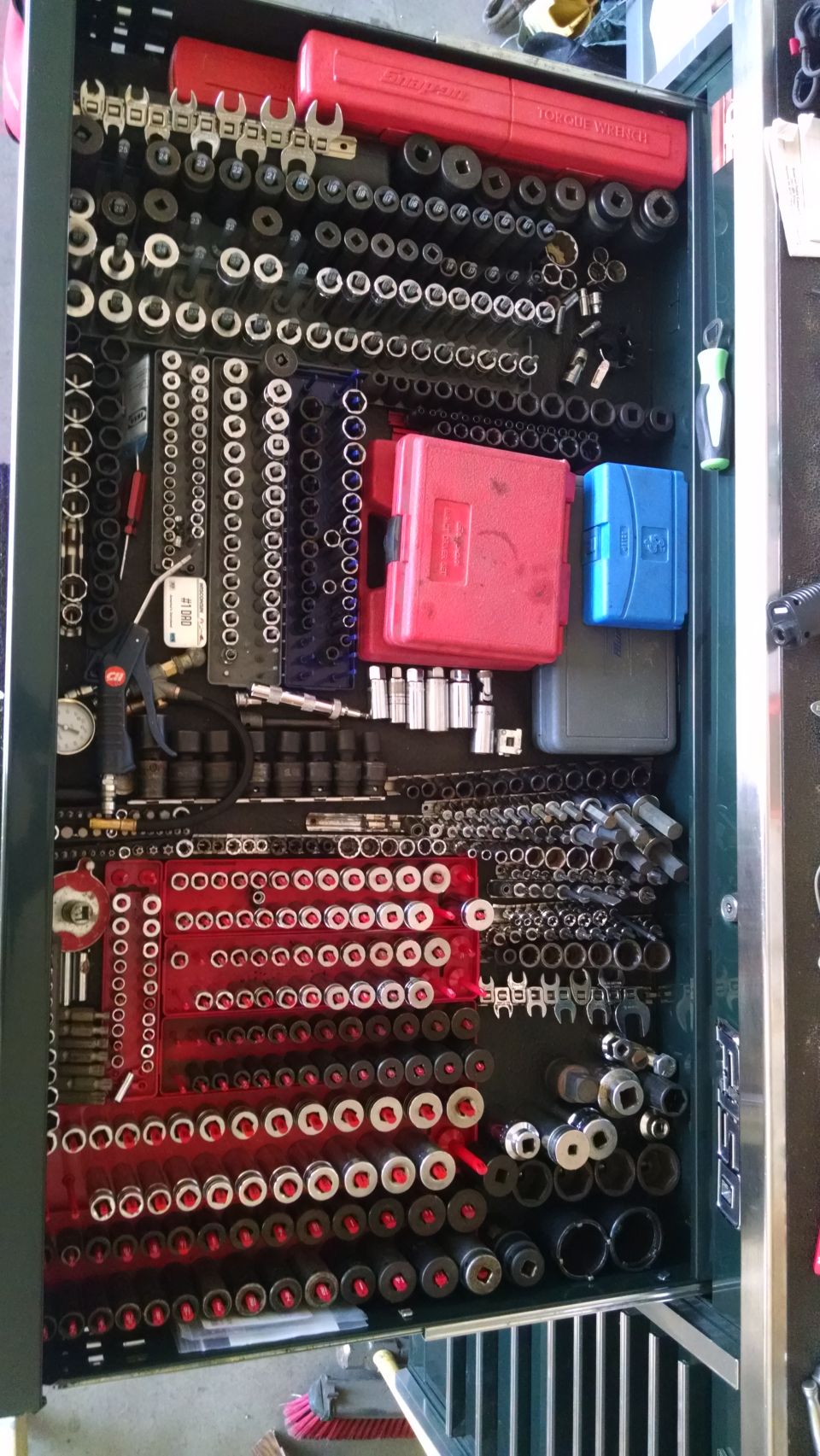Mechanic's toolbox drawer filled with sockets, wrenches, and tools.