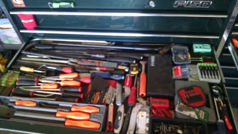 1994 Ford Bronco - A top-down view of an open toolbox drawer filled with various tools, including screwdrivers, wrenches, and utility knives.