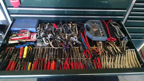 1994 Ford Bronco - An open toolbox drawer filled with various hand tools, including pliers, wrenches, and cutters. The tools are organized on a wire rack with…