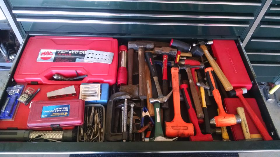 A toolbox drawer filled with various hand tools, primarily hammers.