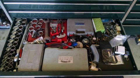 1994 Ford Bronco - This is a top-down view of an open toolbox drawer filled with various automotive tools. Visible items include a set of socket wrenches, pip…