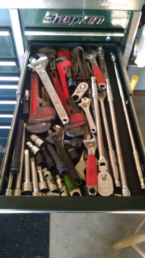 1994 Ford Bronco - A top-down view of an open toolbox drawer filled with various wrenches, ratchets, and other hand tools. The toolbox is dark green with a "S…