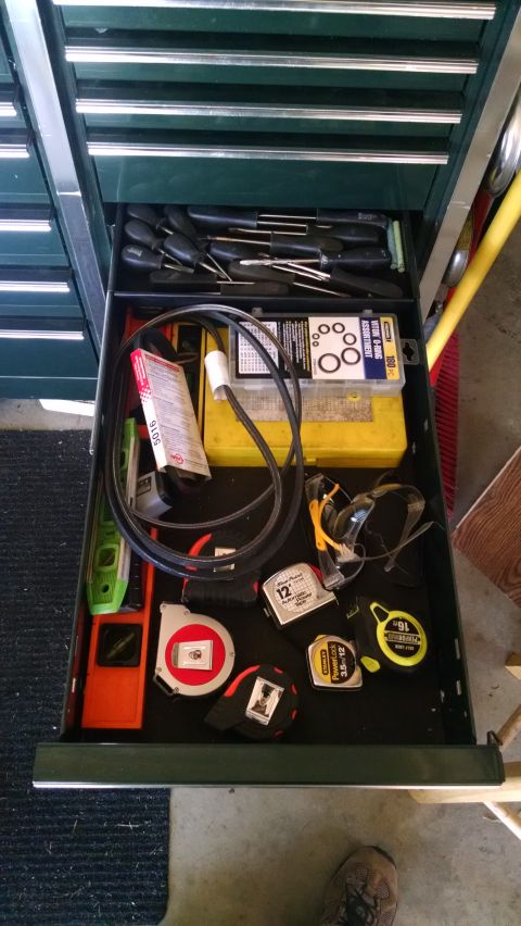 1994 Ford Bronco - An open toolbox drawer filled with various tools including screwdrivers, tape measures, a level, safety glasses, and a box of O-rings.