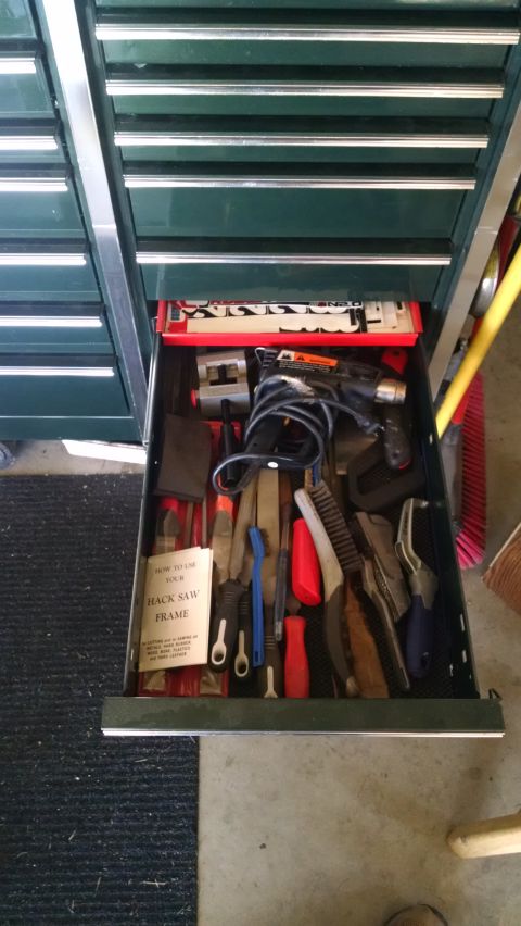 1994 Ford Bronco - An open toolbox drawer is filled with various hand tools, including files, brushes, pliers, and a heat gun. A folded instruction manual for…