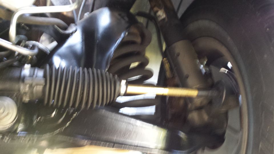 Close-up of vehicle front suspension and steering linkage.