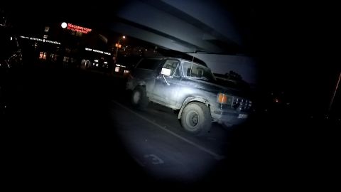1987 Ford Bronco - A dark-colored Ford Bronco is parked under an overpass at night. The vehicle is dirty and appears to be an older model.