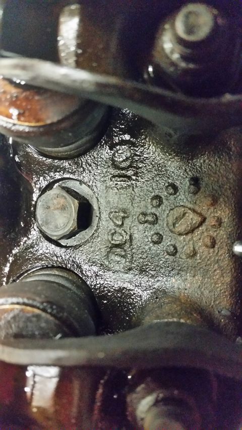 2015 Chevrolet new - Close-up of cast iron engine component with stamped markings. Visible text includes "911" and "534", along with several circular indentatio…