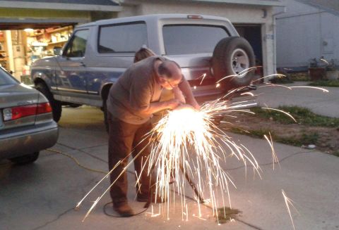 1996 Ford Bronco - A man grinds metal in front of a Ford Bronco, creating a shower of sparks.