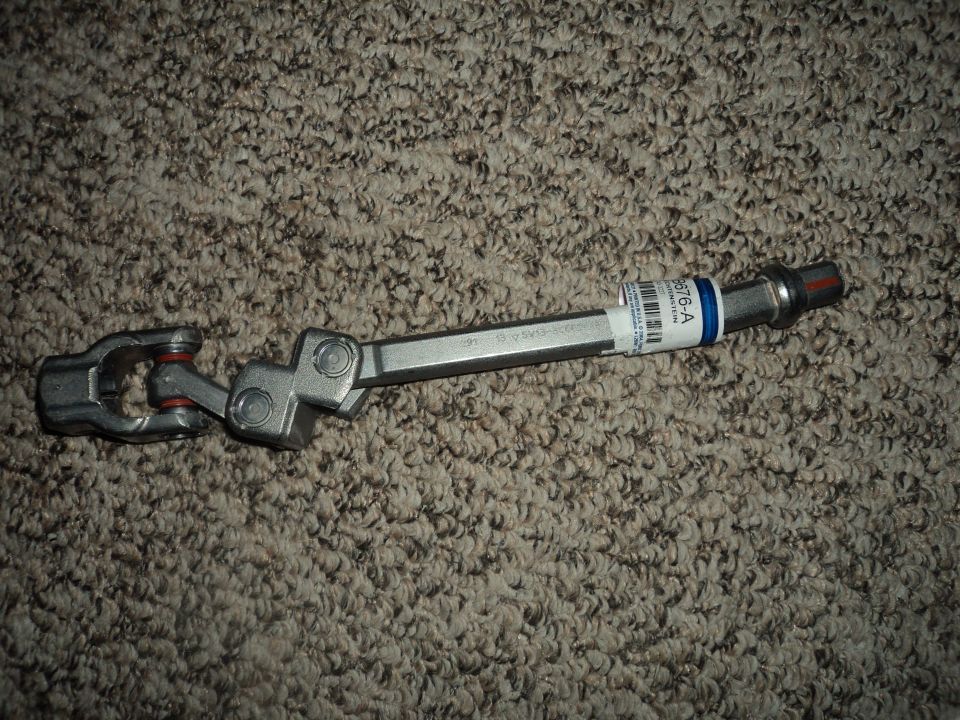 Steering column intermediate shaft with a U-joint on one end and a splined shaft on the other. It has a label with part number 6076-A