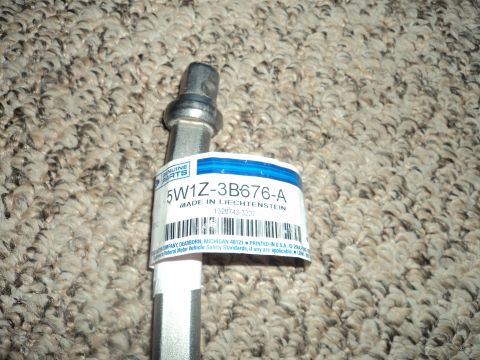 2004 Mercury Grand Marquis - A close-up of a metal automotive part with a label indicating it is a genuine part.