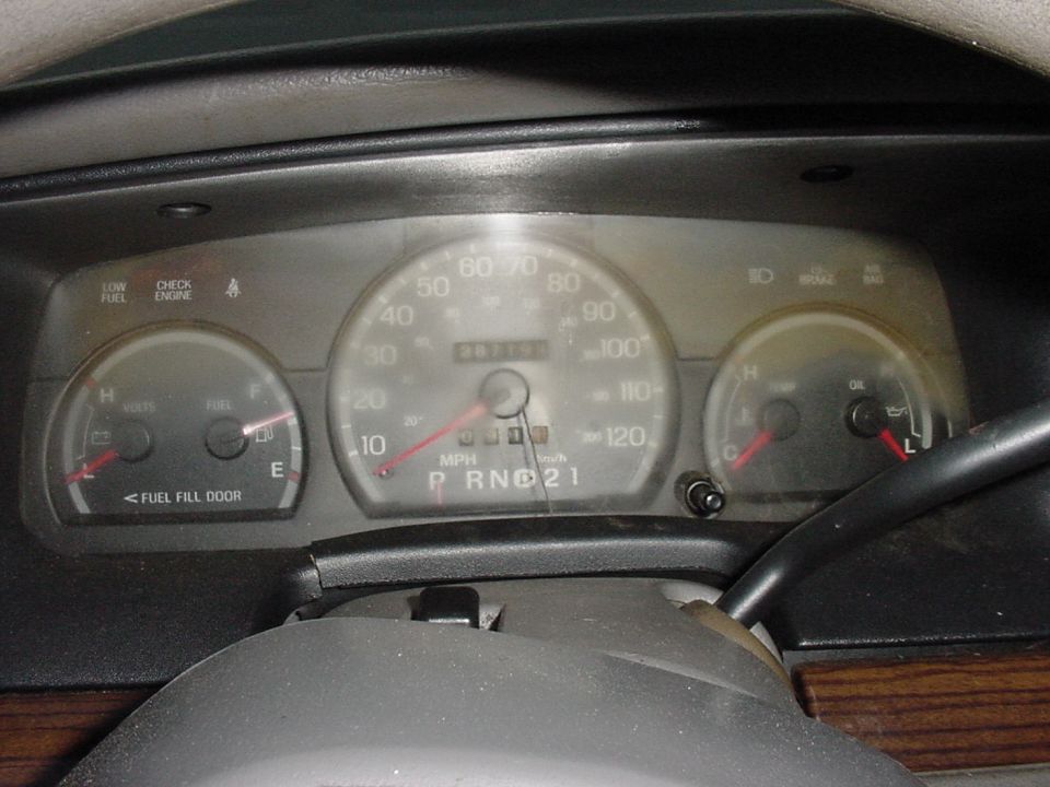 Dashboard gauges of a 2001 Ford Crown Victoria showing 30715 miles, fuel, oil, and speed