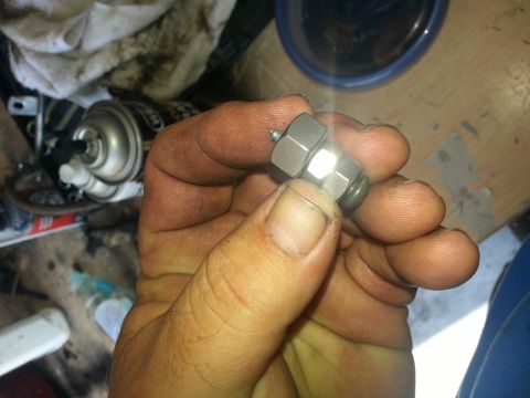 1994 Ford Bronco - A hand holds a metal fitting, possibly a sensor or valve component.