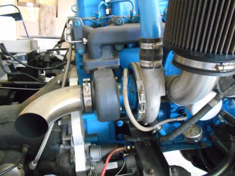 1992 Ford Bronco - Close-up view of an engine a turbocharger and bright blue components.