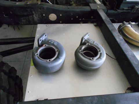1992 Ford Bronco - Two turbocharger housings are shown, one larger than the other, on a flat metal surface.