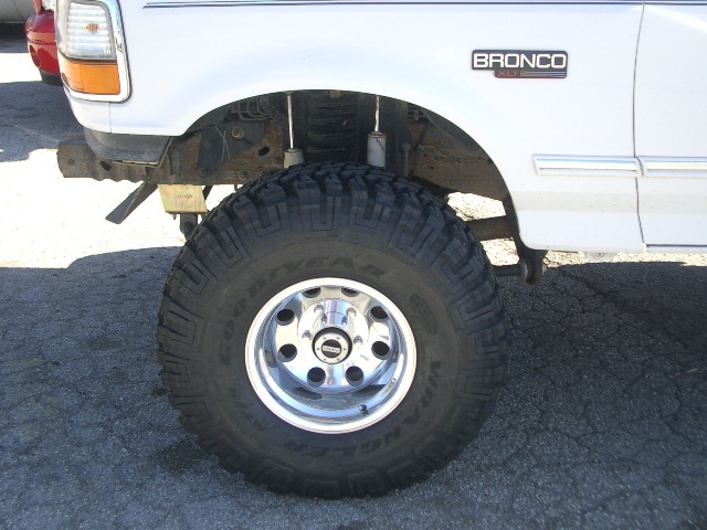 White 1994 Ford Bronco front fender and large off-road tire, showing "BRONCO" badge