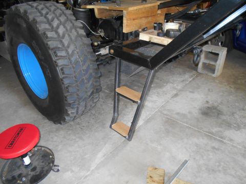1992 Ford Bronco - Custom steps are installed next to a large tire with a blue rim, with a Craftsman stool nearby.