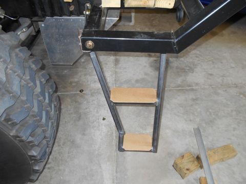 1992 Ford Bronco - Custom metal steps with wooden treads are attached to the frame of a vehicle.