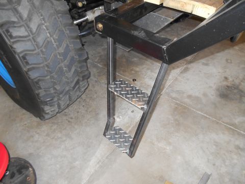 1992 Ford Bronco - A close-up view shows custom metal steps mounted to the side of a vehicle's frame, next to a large tire.