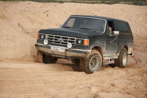 1987 Ford Bronco - 1987 Ford Bronco navigating sandy terrain.