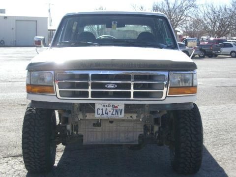1994 Ford Bronco - Front view of a white Ford Bronco with a chrome grille and off-road tires.
