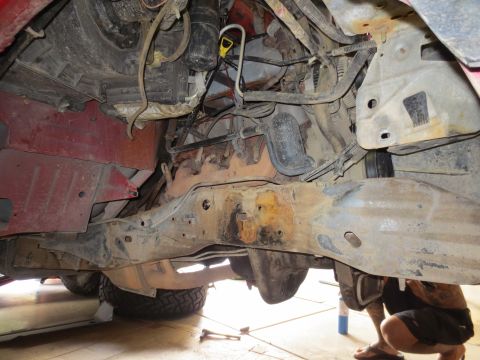 1996 Ford Bronco - The photo shows the underside of a vehicle, focusing on the engine and chassis with visible signs of wear and rust.