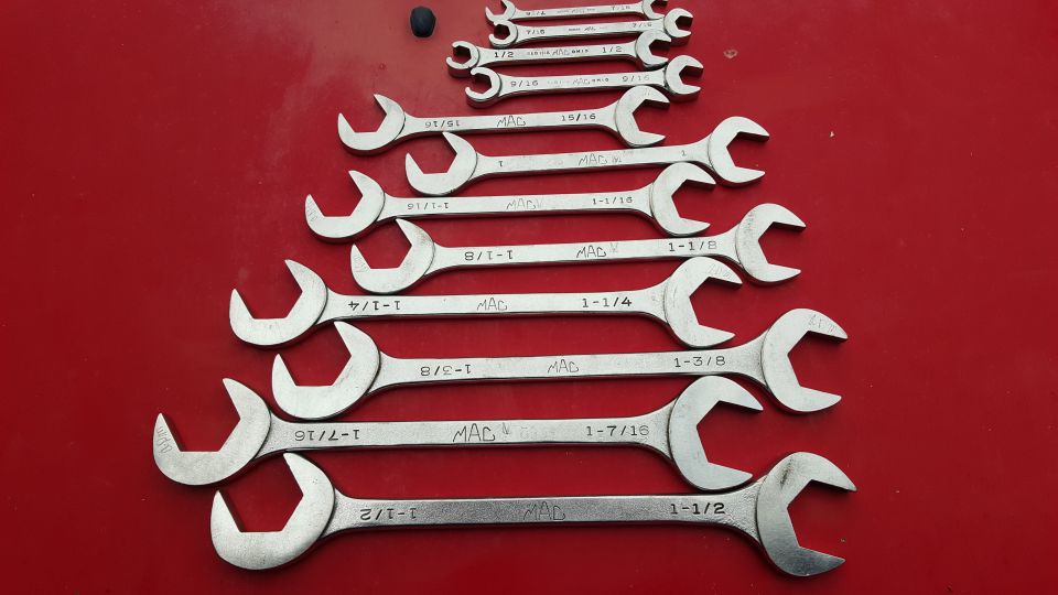 MAC wrenches laid out on red surface. Sizes range from 1/2 inch to 1-1/2 inch