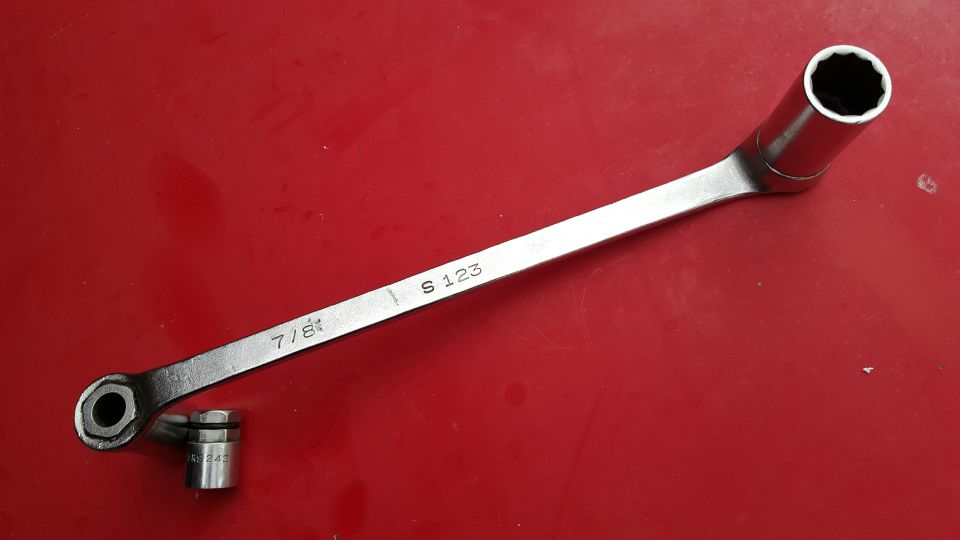 7/8 inch socket wrench with a 12mm socket attached, on a red surface