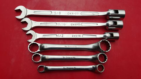 1965 Ford Mustang - A collection of five wrenches, various sizes and brands, laid out on a red surface.