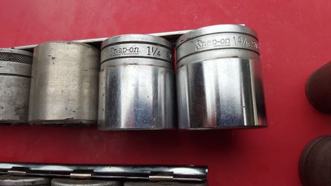 1965 Ford Mustang - A collection of Snap-on sockets are displayed on a red surface, with visible size markings on some.