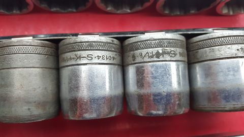 1965 Ford Mustang - A collection of metal sockets, some with visible part numbers, are neatly arranged in a red case.