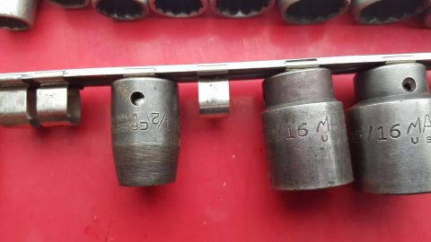 1965 Ford Mustang - A set of sockets, some marked with sizes like 1/2 inch and 5/16 inch, are mounted on a rail.