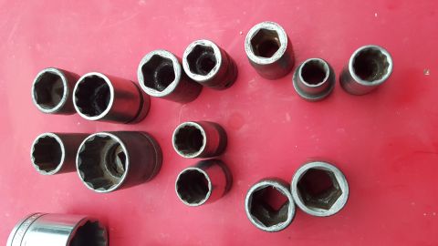 1965 Ford Mustang - A collection of various socket wrenches are laid out on a red background.
