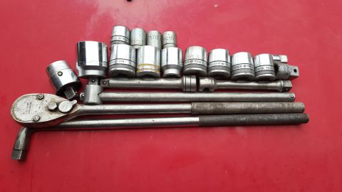 1965 Ford Mustang - A collection of socket wrenches and extensions are laid out on a red surface.