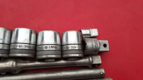 1965 Ford Mustang - A collection of socket wrenches and extensions are laid out on a red surface.