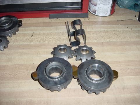 1989 Ford Bronco - Several metal gears and a clip are laid out on a wooden surface, with a Supermotors.net watermark visible.